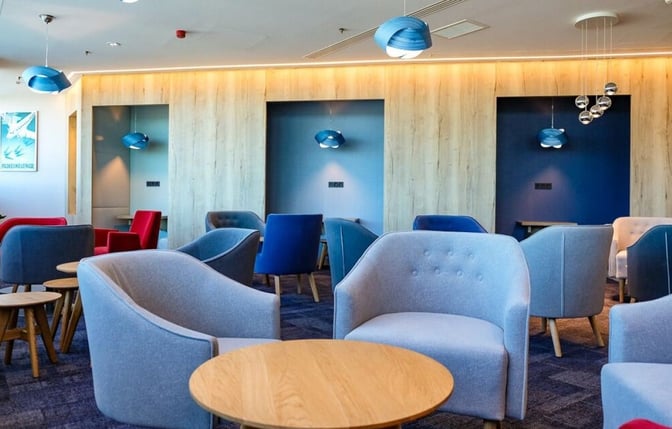The seating area in Plaza Premium Lounge at Budapest Airport features comfortable chairs and tables for relaxation and work.