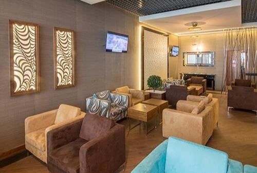 The Platinum Lounge at Budapest Airport features a seating area with armchairs and televisions, providing a comfortable waiting space.