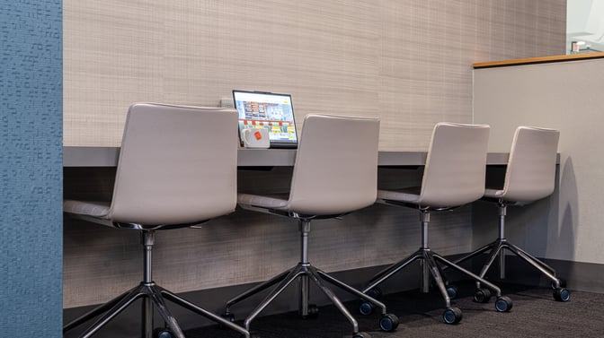 Workstations at The Club BUF in Buffalo Niagara International Airport offer seating with a counter, laptop, and complimentary beverage service.