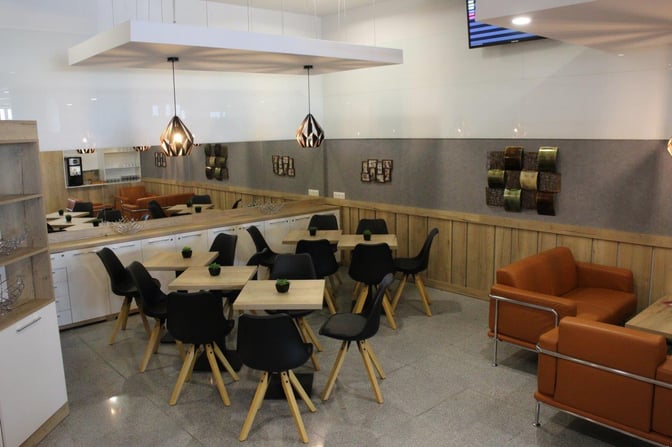The seating area in Burgas Airport Lounge features tables with chairs and sofas, providing a comfortable space for travelers.