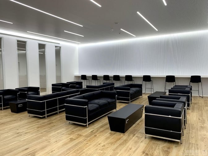 The Prima Vista Lounge at Cagliari Elmas Airport features a seating area with sofas and a counter with bar stools.