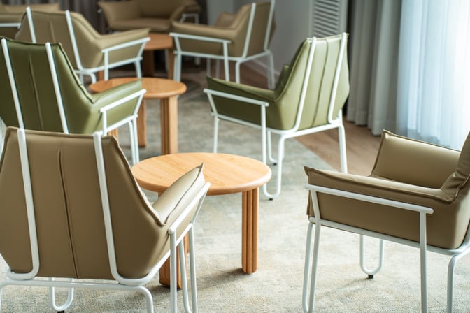The seating area in Cairns Airport's Escape Lounge features comfortable chairs and small tables arranged for relaxation and conversation.