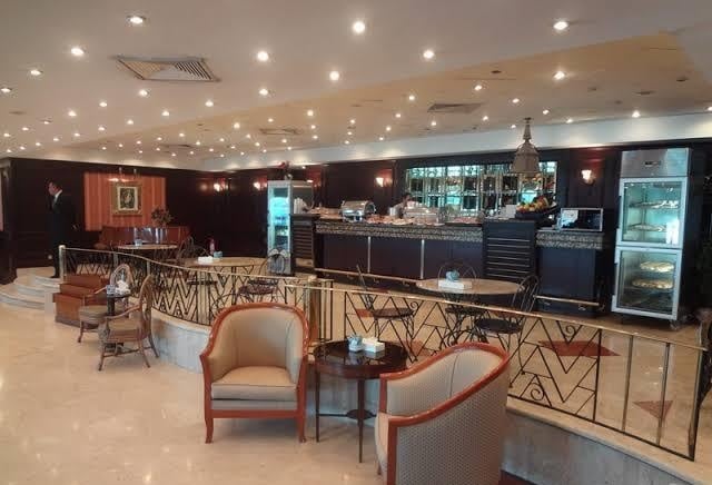 The CAC Lounge at Cairo International Airport Terminal 1 features a bar area with seating and a selection of refreshments available.