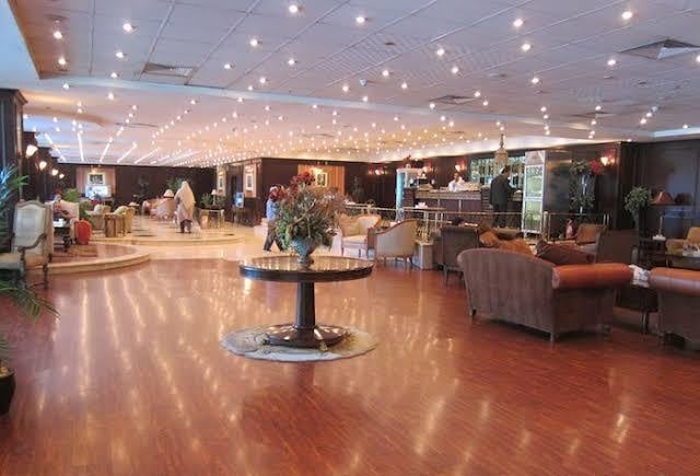 The CAC Lounge at Cairo International Airport Terminal 1 features a spacious seating area with sofas and a bar offering refreshments.