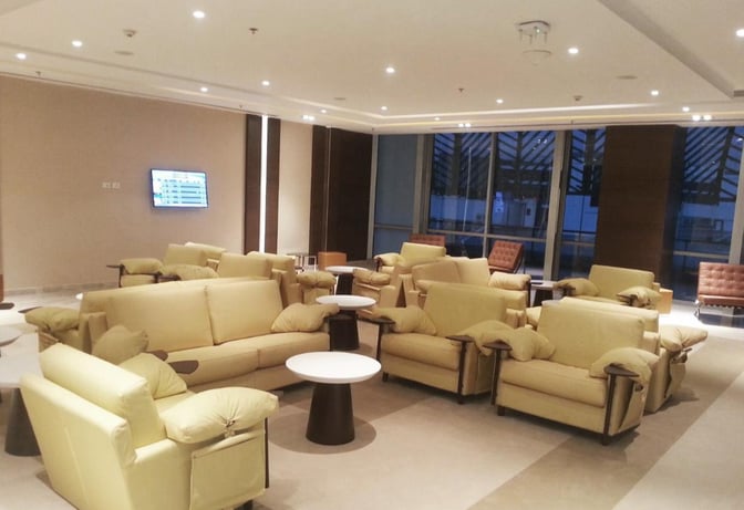 The seating area in the CAC Lounge at Cairo International Airport features comfortable armchairs and sofas with small tables for travelers.