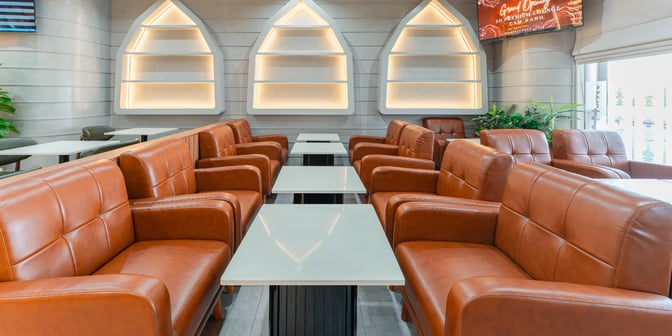 The seating area in SH Premium Lounge at Cam Ranh International Airport features cushioned chairs and tables for passenger comfort.