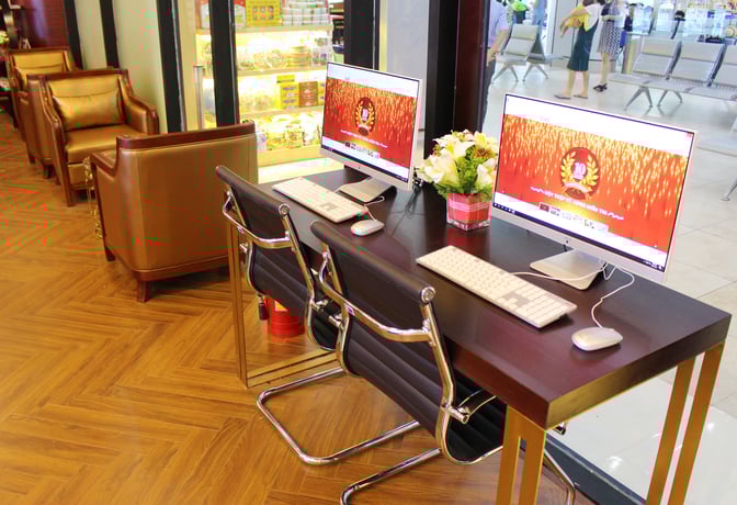 The Champ Lounge at Cam Ranh International Airport features a computer station with two desktop computers and comfortable seating nearby.