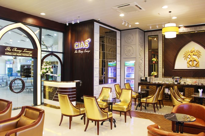 The Champ Lounge at Cam Ranh International Airport features a reception area and seating with tables, offering a comfortable waiting space.