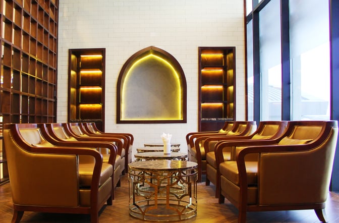 The seating area in The Champ Lounge at Cam Ranh International Airport features comfortable armchairs and small tables for relaxation.