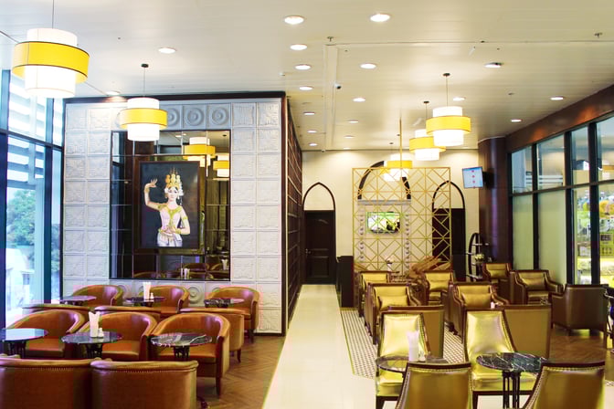 The Champ Lounge at Cam Ranh International Airport features comfortable seating areas with small tables and decorative wall art.