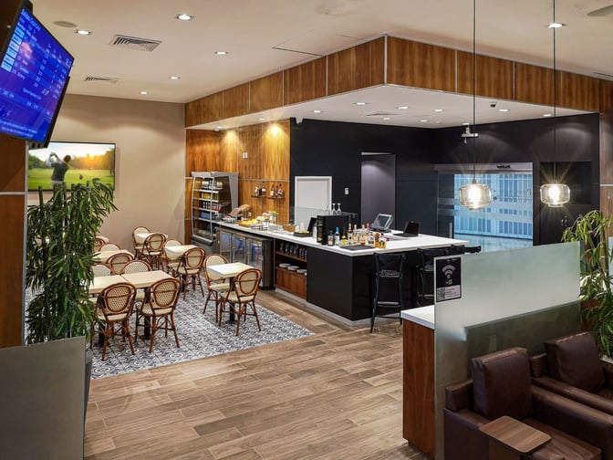 The MERA Business Lounge in Terminal 2 at Cancun International Airport features a bar with seating and a dining area with tables.