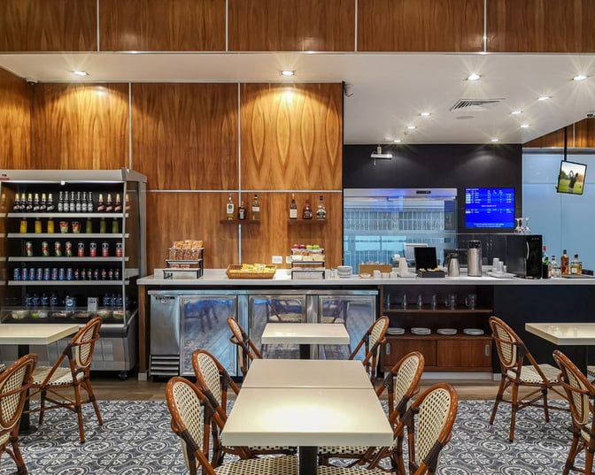 The MERA Business Lounge at Cancun International Airport Terminal 2 features a self-serve beverage and snack area with seating.