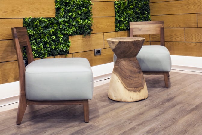 Seating area in the MERA Business Lounge at Cancun International Airport features cushioned chairs and a wooden table with greenery accents.