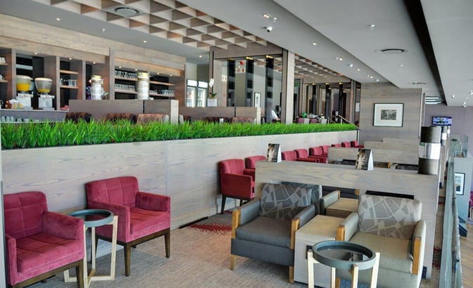 The Bidvest Premier Lounge at Cape Town International Airport features comfortable seating with tables, offering a relaxing space for travelers.