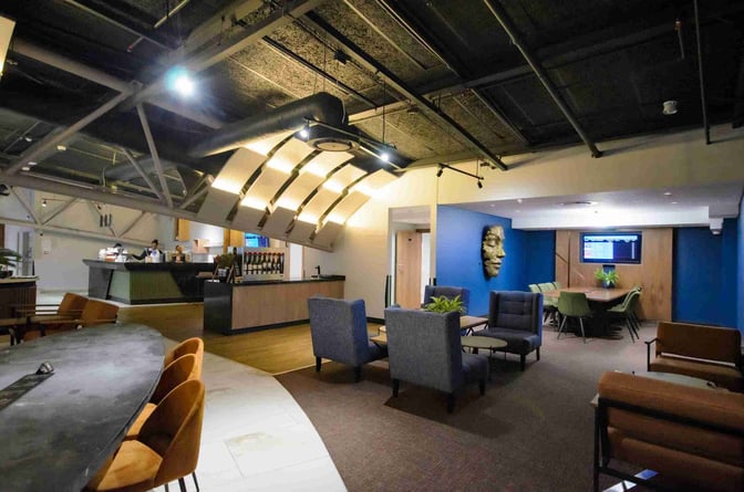 The Bidvest Premier Lounge at Cape Town International Airport features a seating area with tables and a service counter for refreshments.