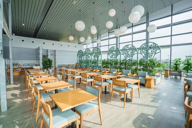 The SH Premium Lounge at Cat Bi International Airport features a spacious seating area with tables, chairs, and decorative partitions.