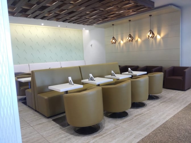 The seating area at The Cram Bar in Chandigarh Airport features booth and chair seating with tables for dining or relaxation.
