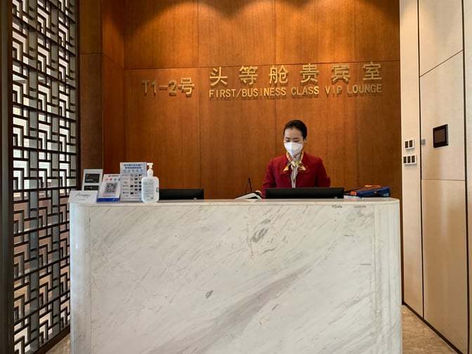 The reception desk at Changsha Huanghua International Airport's No. 2 First/Business Class VIP Lounge at Terminal 1 features a staff member ready to assist guests.