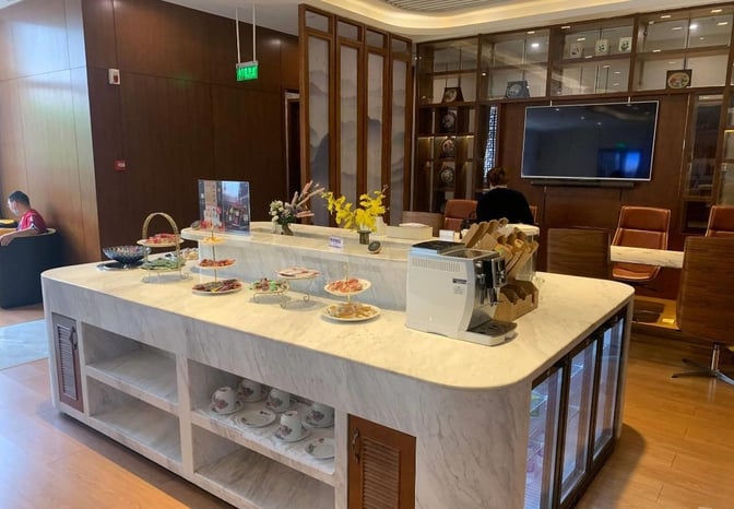 The No.6 Business Lounge at Changsha Huanghua International Airport features a self-serve food station with snacks and a coffee machine.