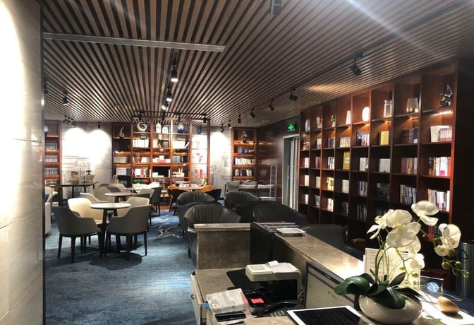The Book Bar at Changsha Huanghua International Airport features seating areas with tables and bookshelves, providing a relaxing space for travelers.