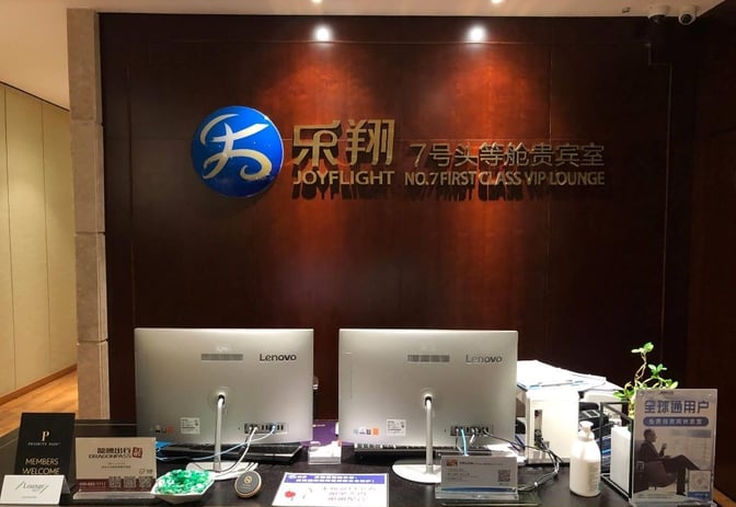 The reception area of Joyflight No.7 First Class Lounge at Changsha Huanghua International Airport features check-in desks and informational signage.