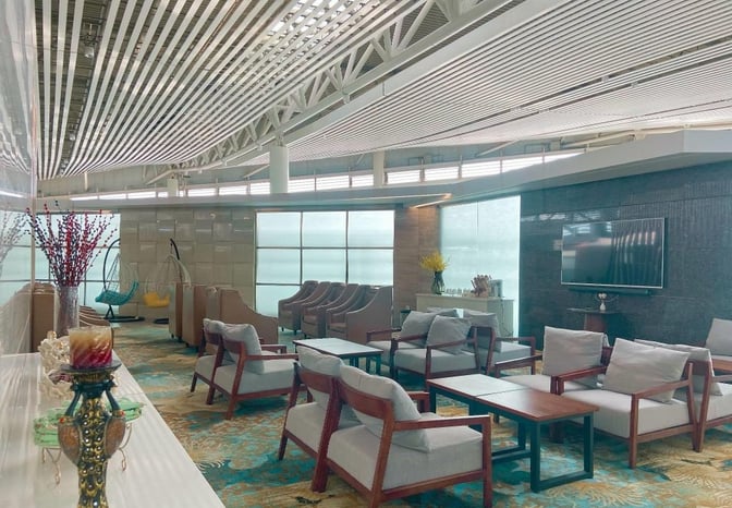 The Joyflight Network Reservation Lounge at Changsha Huanghua International Airport features seating areas with armchairs, tables, and a wall-mounted television.
