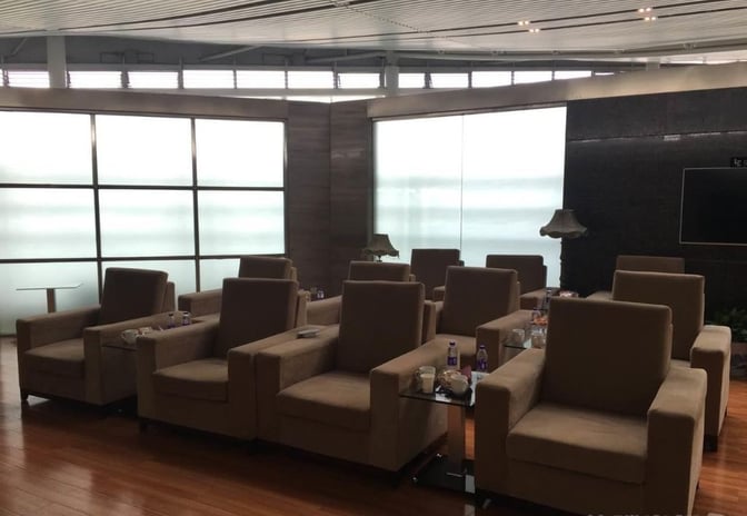 The seating area in the Joyflight Network Reservation Lounge at Changsha Huanghua International Airport features armchairs and small tables for passenger comfort.