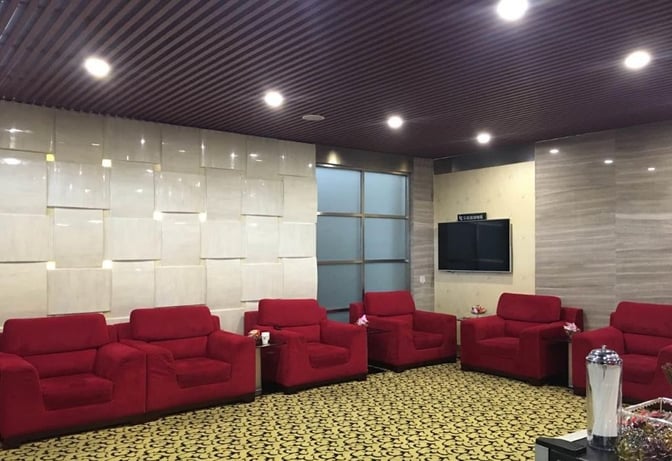 The seating area in the Joyflight Network Reservation Lounge at Changsha Huanghua International Airport features comfortable armchairs and a wall-mounted television.