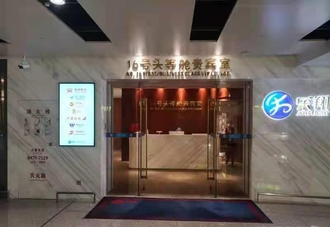The entrance to the No. 16 First/Business Class VIP Lounge at Changsha Huanghua International Airport features glass doors and a reception desk.