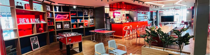 The Budweiser Bar at Chaudhary Charan Singh International Airport features a counter bar, seating area, and games like foosball and table tennis.