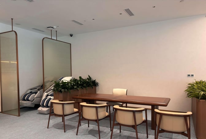 The lounge at Chengdu Shuangliu International Airport features massage chairs and a meeting table with seating, offering relaxation and workspace.