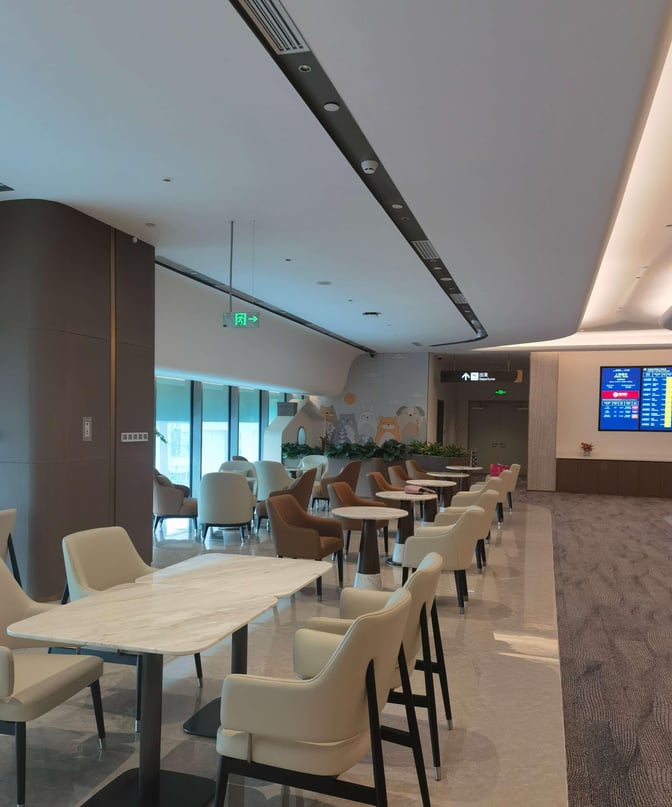 The seating area in Chengdu Shuangliu International Airport's airline lounge features tables and chairs for dining and relaxation.