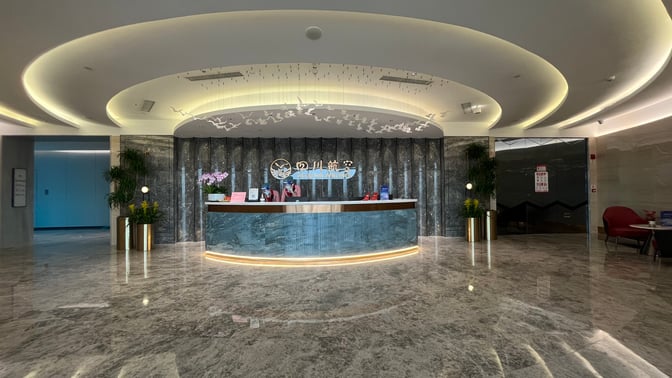 The Sichuan Airlines Lounge entrance at Chengdu Tianfu International Airport features a reception desk with airline branding and decorative elements.