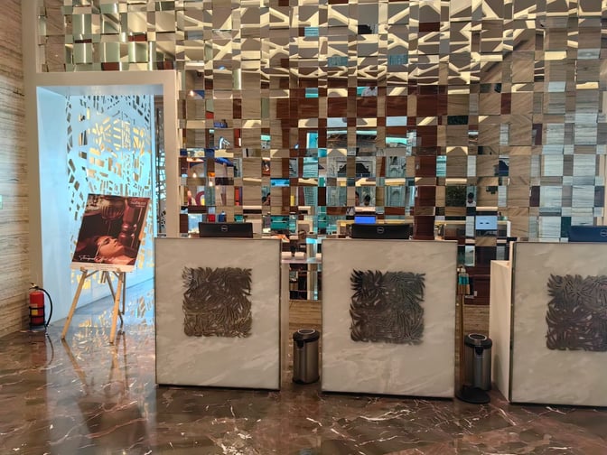 The Adani East Lounge entrance at Chhatrapati Shivaji International Airport features a reception area with decorative panels and check-in counters.
