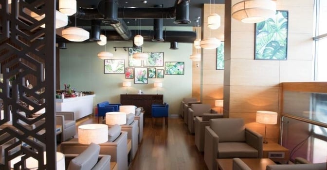 The Adani Lounge at Chhatrapati Shivaji International Airport features comfortable seating with individual lamps and a self-serve refreshment area.