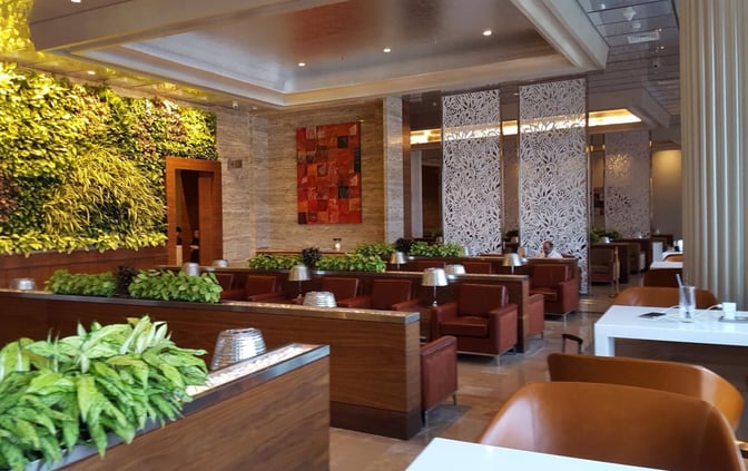 The Adani Lounge at Chhatrapati Shivaji International Airport features seating areas with partitioned sections and a vertical garden wall.