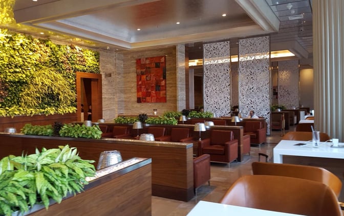 The Adani Lounge at Chhatrapati Shivaji International Airport features seating areas with partitioned sections and a vertical garden wall.