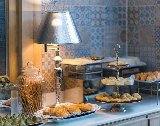 The food area at Bangkok Airways Blue Ribbon Lounge in Chiang Mai Airport offers a selection of pastries and snacks on display.