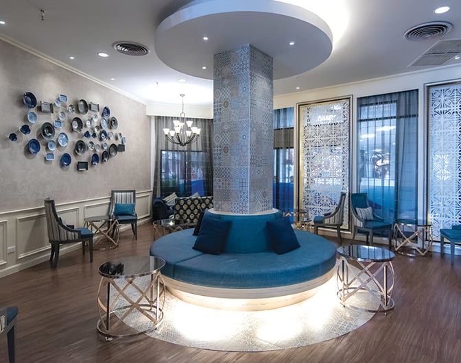 The seating area in Bangkok Airways Blue Ribbon Lounge at Chiang Mai International Airport features circular seating around a central pillar.