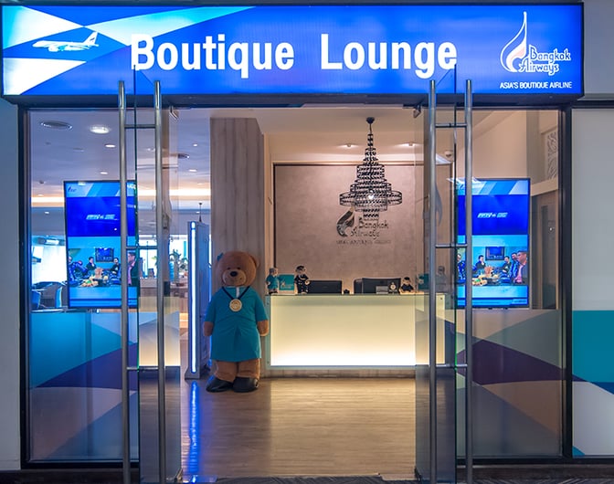 The entrance to Bangkok Airways Boutique Lounge at Chiang Mai International Airport features a reception desk and welcoming decor.