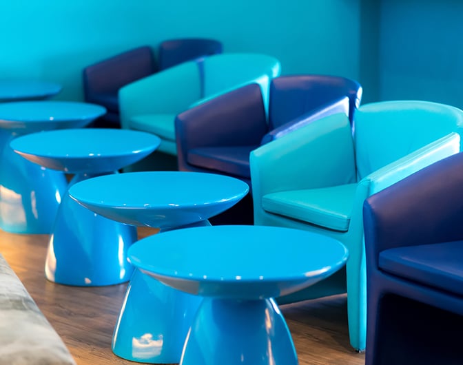 The seating area in Bangkok Airways Boutique Lounge at Chiang Mai Airport features modern chairs and tables for passenger comfort.
