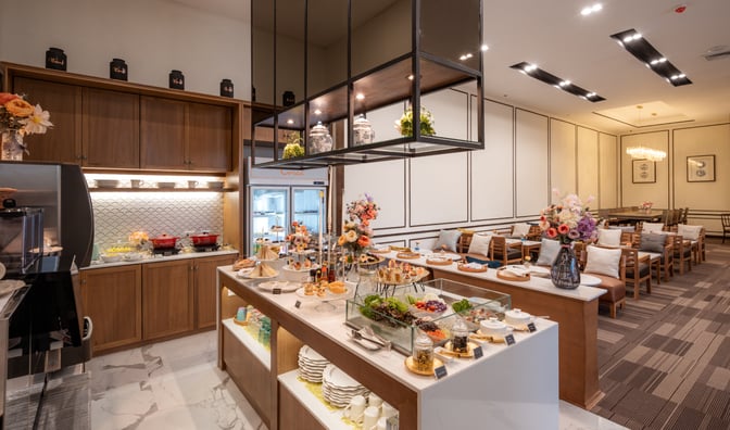 The Coral Executive Lounge at Chiang Mai International Airport features a self-serve buffet with a variety of snacks and seating areas.