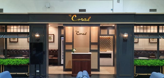 The Coral Executive Lounge entrance at Mae Fah Luang International Airport features a reception desk and visible seating area.
