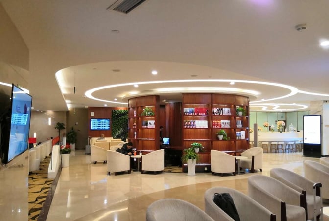 The China Southern Lounge at Chongqing Jiangbei Airport features seating areas, a central bookshelf, and a bar with high stools.
