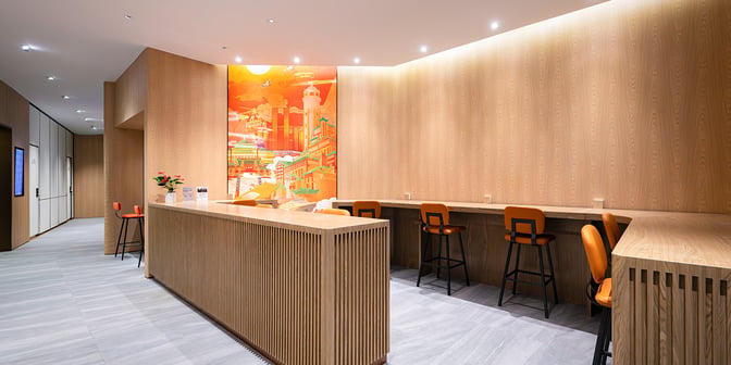 The Plaza Premium Lounge at Chongqing Jiangbei International Airport features a seating area with high stools and a counter for work or dining.