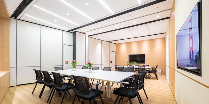 The meeting room at Plaza Premium Lounge, Chongqing Jiangbei Airport, features a large conference table, chairs, and a wall-mounted screen.