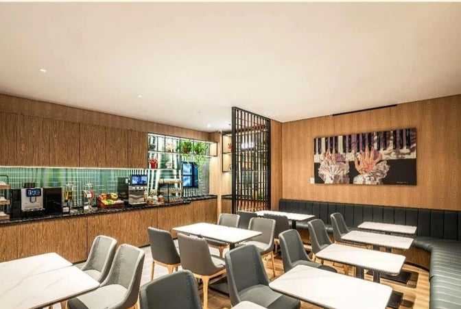 The Plaza Premium Lounge at Chongqing Jiangbei International Airport features a dining area with tables, chairs, and a self-serve food station.