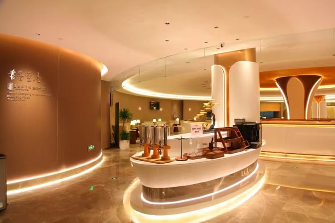 The E Finger Lounge at Chongqing Jiangbei International Airport features a self-serve beverage station with various drink dispensers and seating areas.