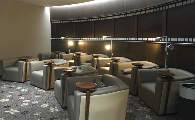 The seating area in Chongqing Jiangbei International Airport's International Lounge features individual chairs with side tables and reading lamps.