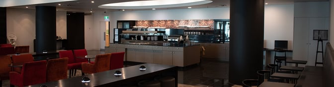 The Manaia Lounge at Christchurch International Airport features a self-serve food area with buffet stations and various seating options.